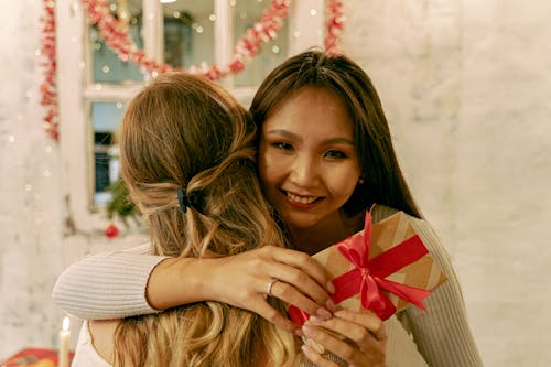 Woman Embracing the Person While Holding a Present 