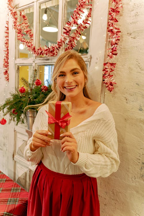 A Woman Holding a Gift in a Box with Red Ribbon