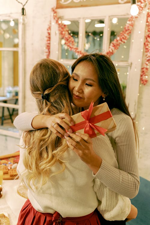 Women in Knitted Sweater Hugging Each Other