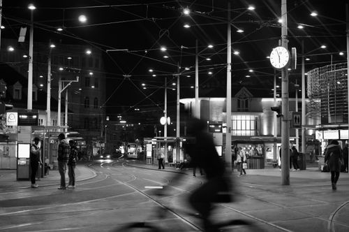 Free Black and white night scene at a tram station in Graz, Austria with people and tram lines. Stock Photo