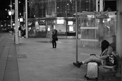 Free Black and white night scene of people waiting at a bus stop in Graz, Austria. Stock Photo
