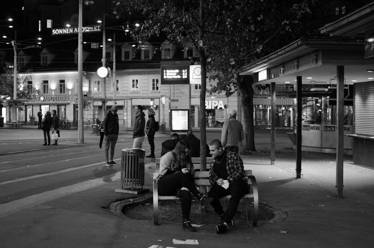 A Man And Woman Sitting On The Bench