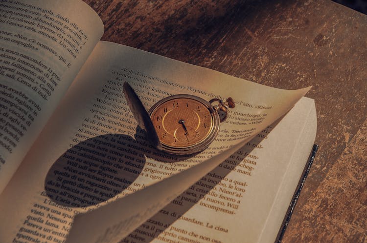 Gold Pocket Watch On A Book Page