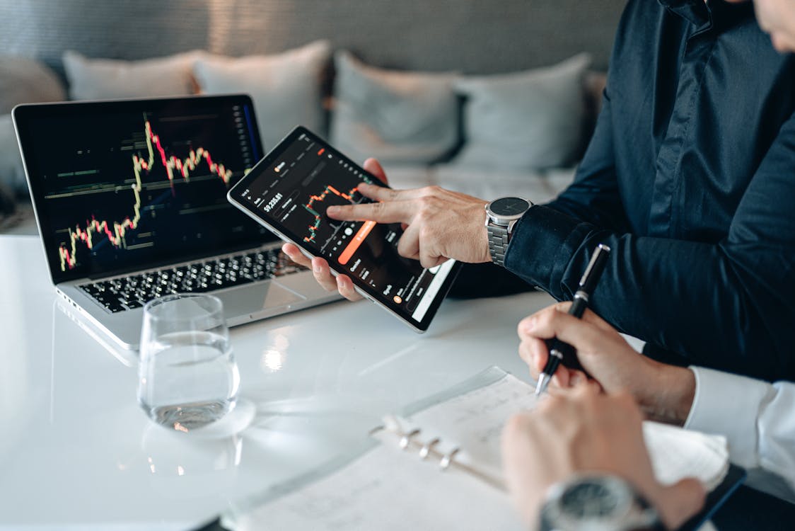 Free Man in Blue Dress Shirt Holding Black Digital Tablet Beside a Person Writing Stock Photo