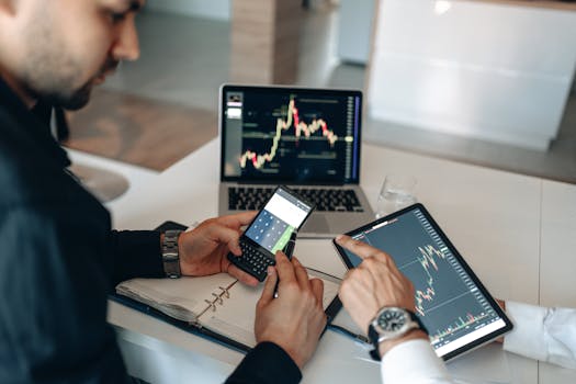 Two professionals examining financial data on digital devices at a modern office.