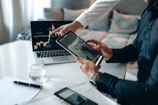 Business professionals analyzing financial data on digital devices in office setting.