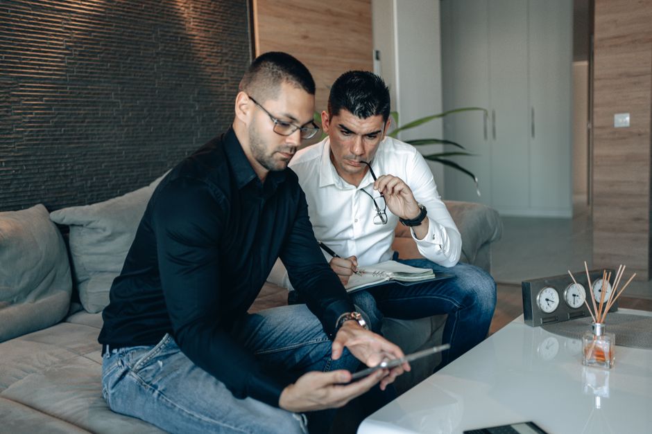 Two men collaborating on a project in a modern office environment. Two men collaborating on a project in a modern office environment.