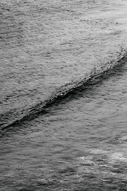 From above of black and white wave of rippling sea on sunny day