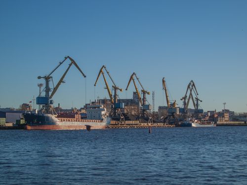 Free Image of an industrial shipyard with cranes and ships on a sunny day. Stock Photo