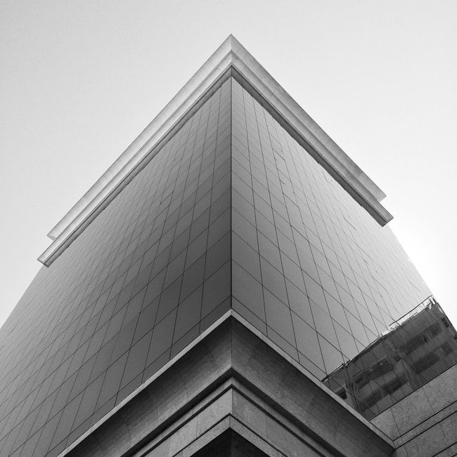 Striking low angle view of modern architecture in grayscale with a bold geometric design.