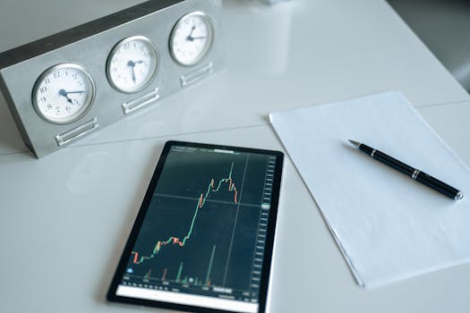 A desk with trading tools, including a tablet showing stock market data and three clocks.
