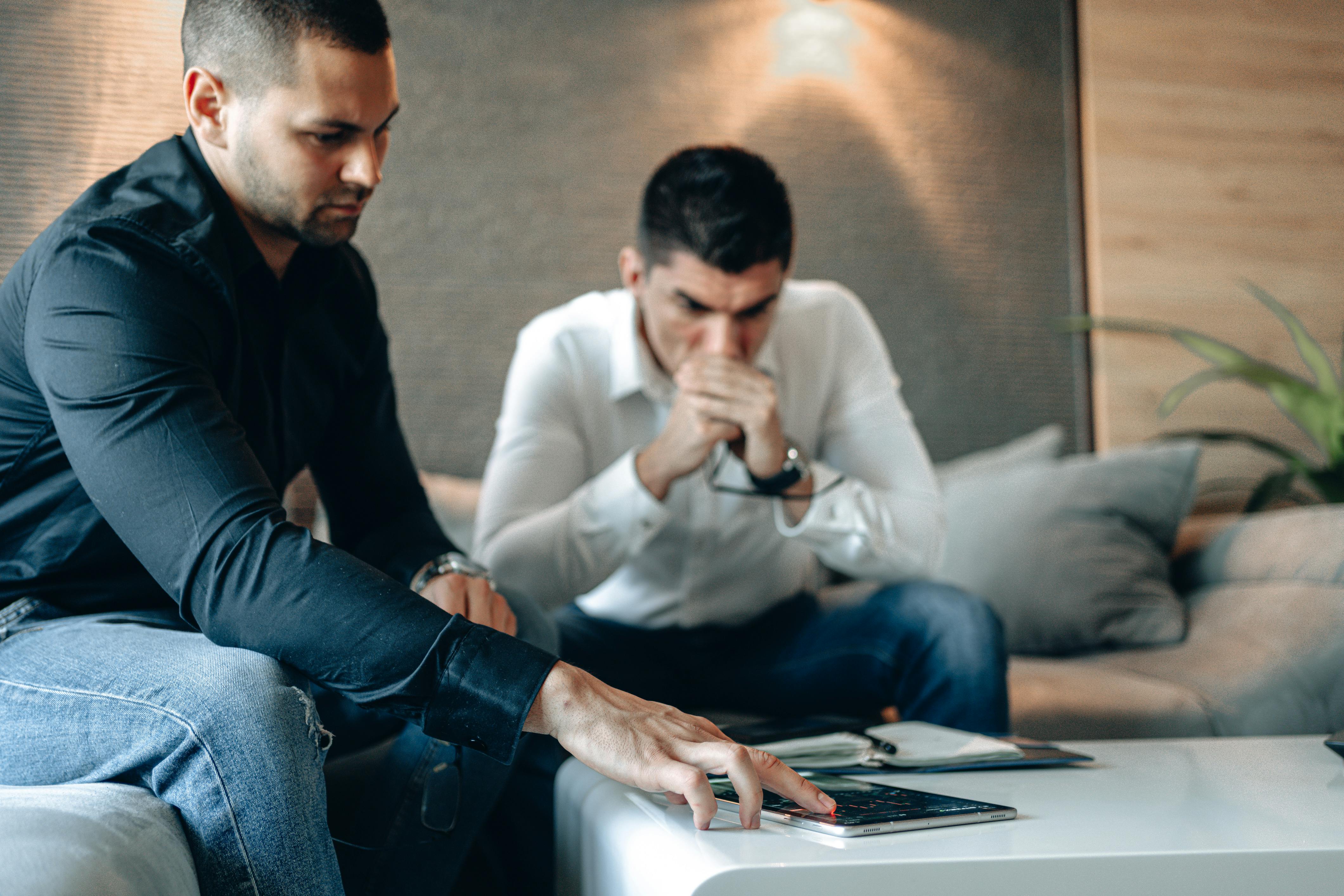 man in black long sleeve shirt touching device on surface