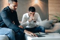 Man in Black Long Sleeve Shirt Touching  Device on Surface