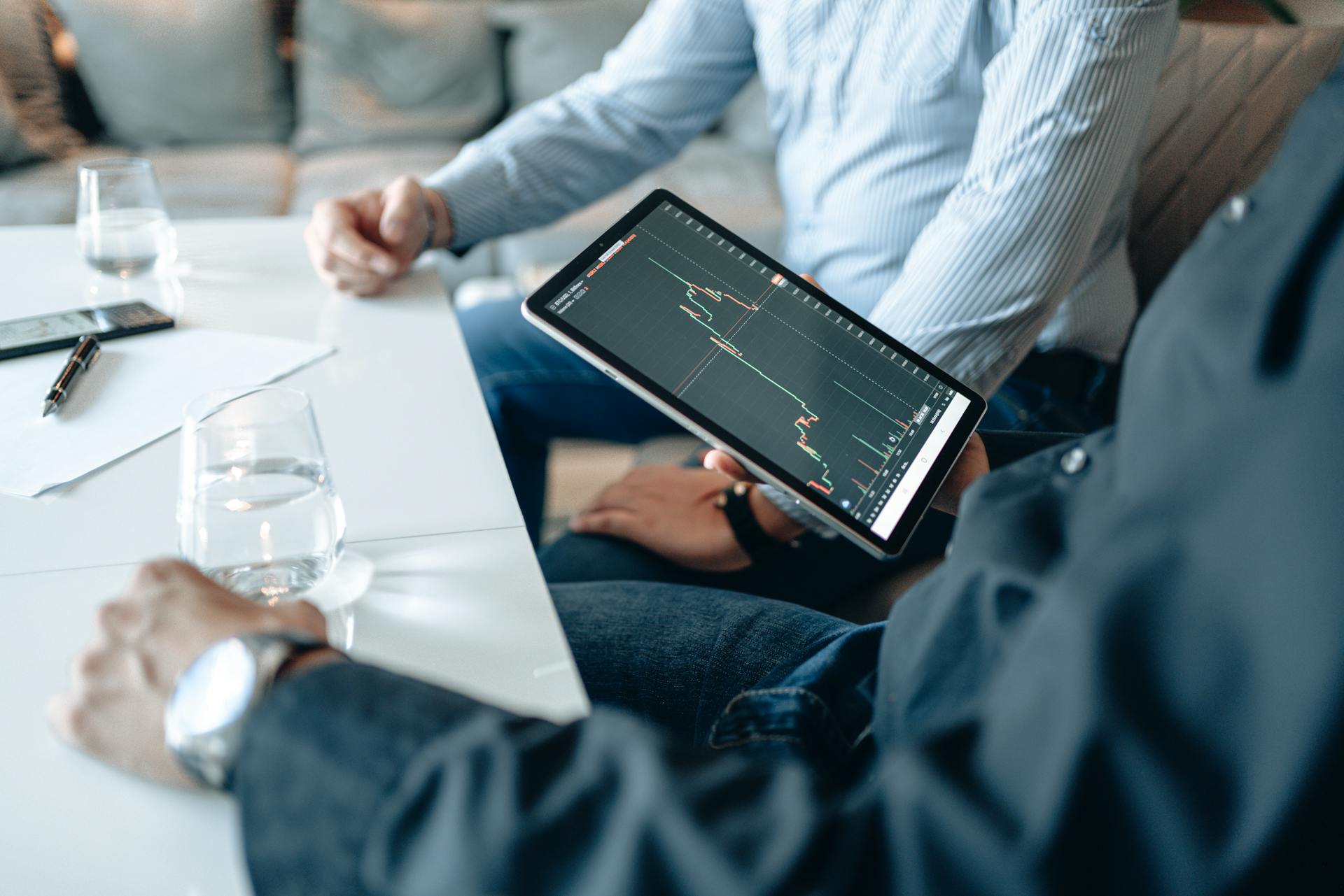 Professionals analyzing business data on a digital tablet during a meeting.