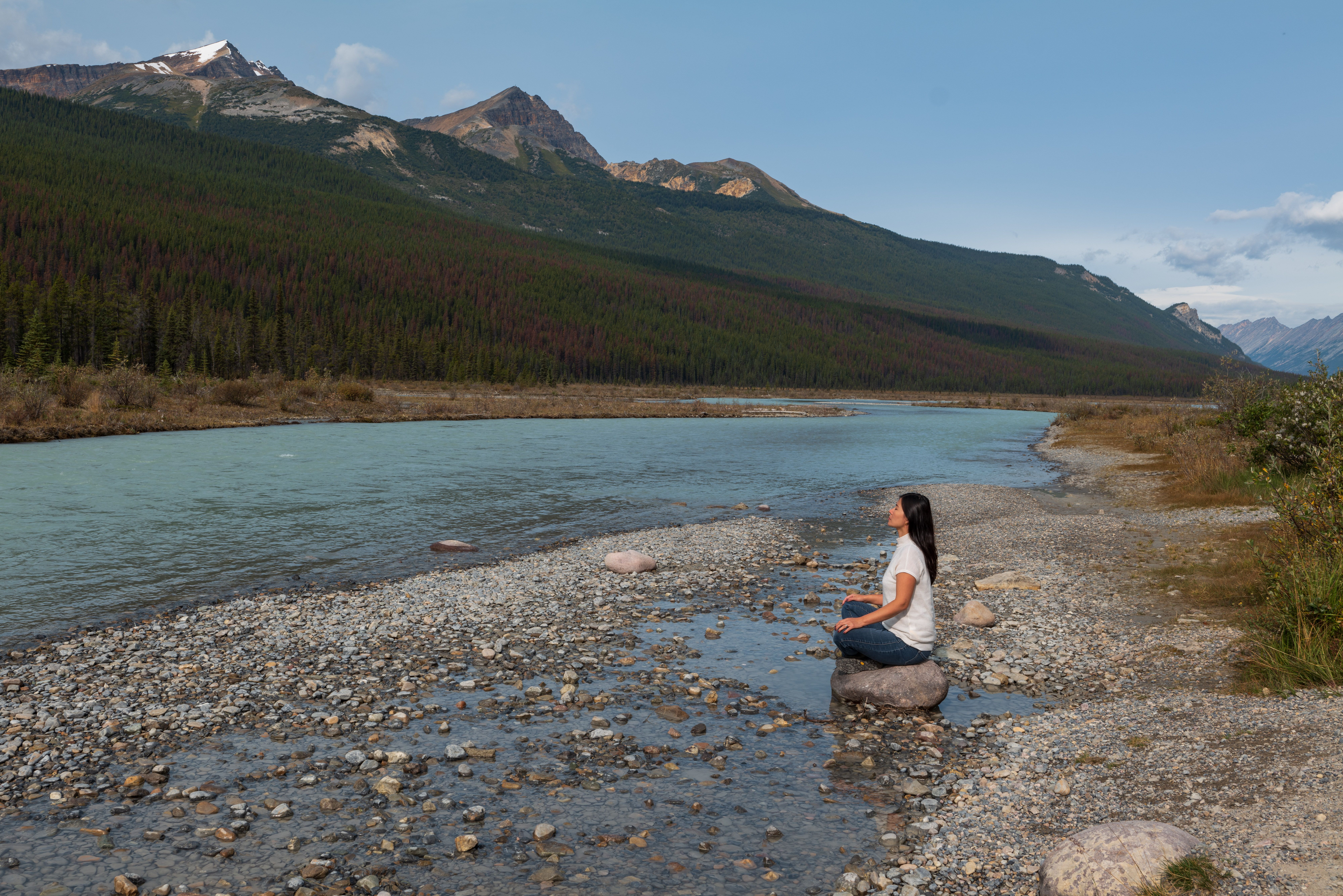 Woman Sitting on a Rock near a Body of Water · Free Stock Photo