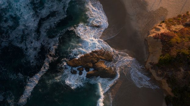 Aerial View of Waves Crashing the Shore with Rocks