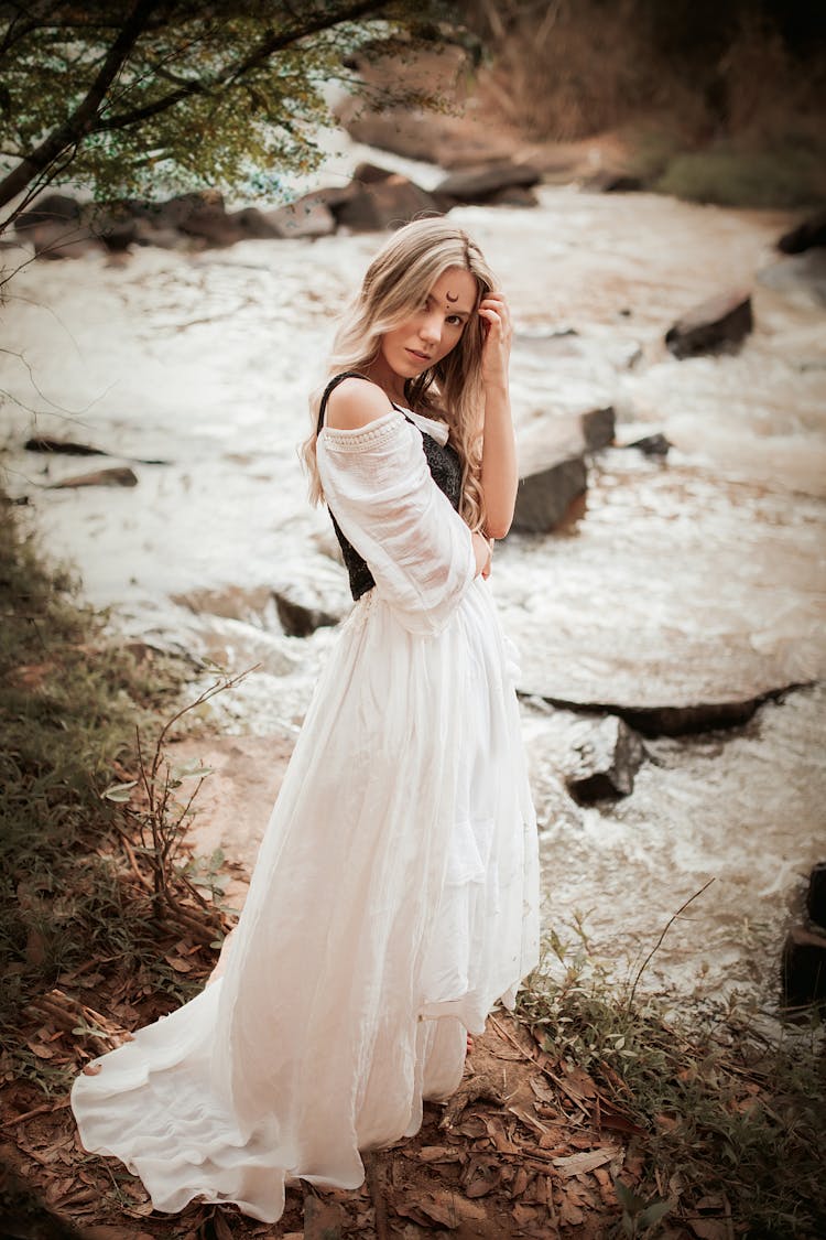 Woman In White Dress Standing On Brown Soil