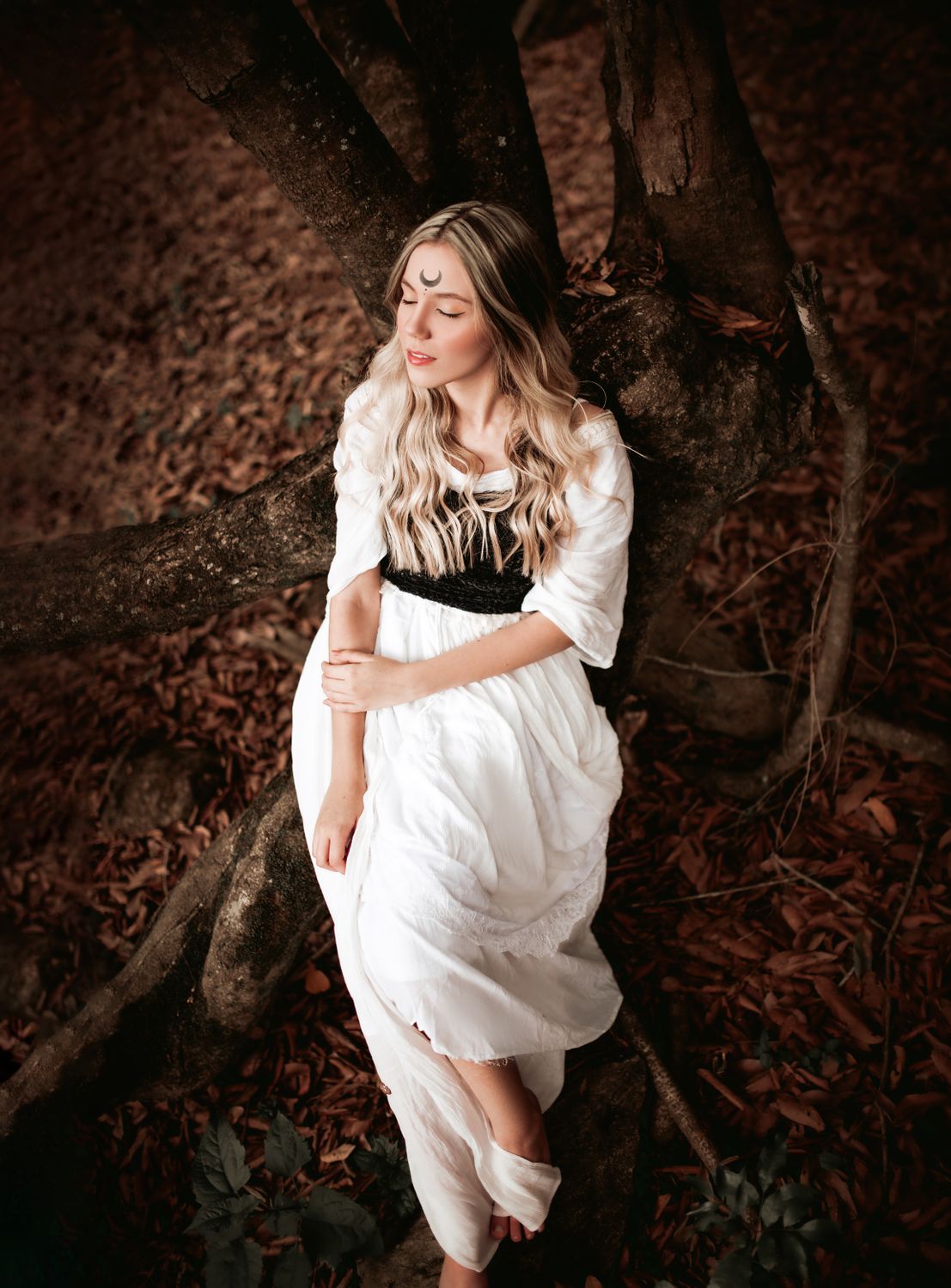 Woman in White Dress Lying Down on Tree Trunks · Free Stock Photo