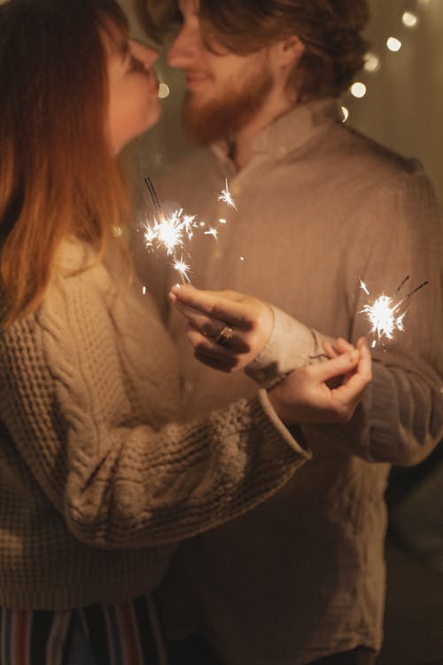 Couple Kissing While Holding Lighted Sparkler