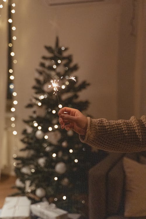 Holding a Sparkler near the Christmas Tree