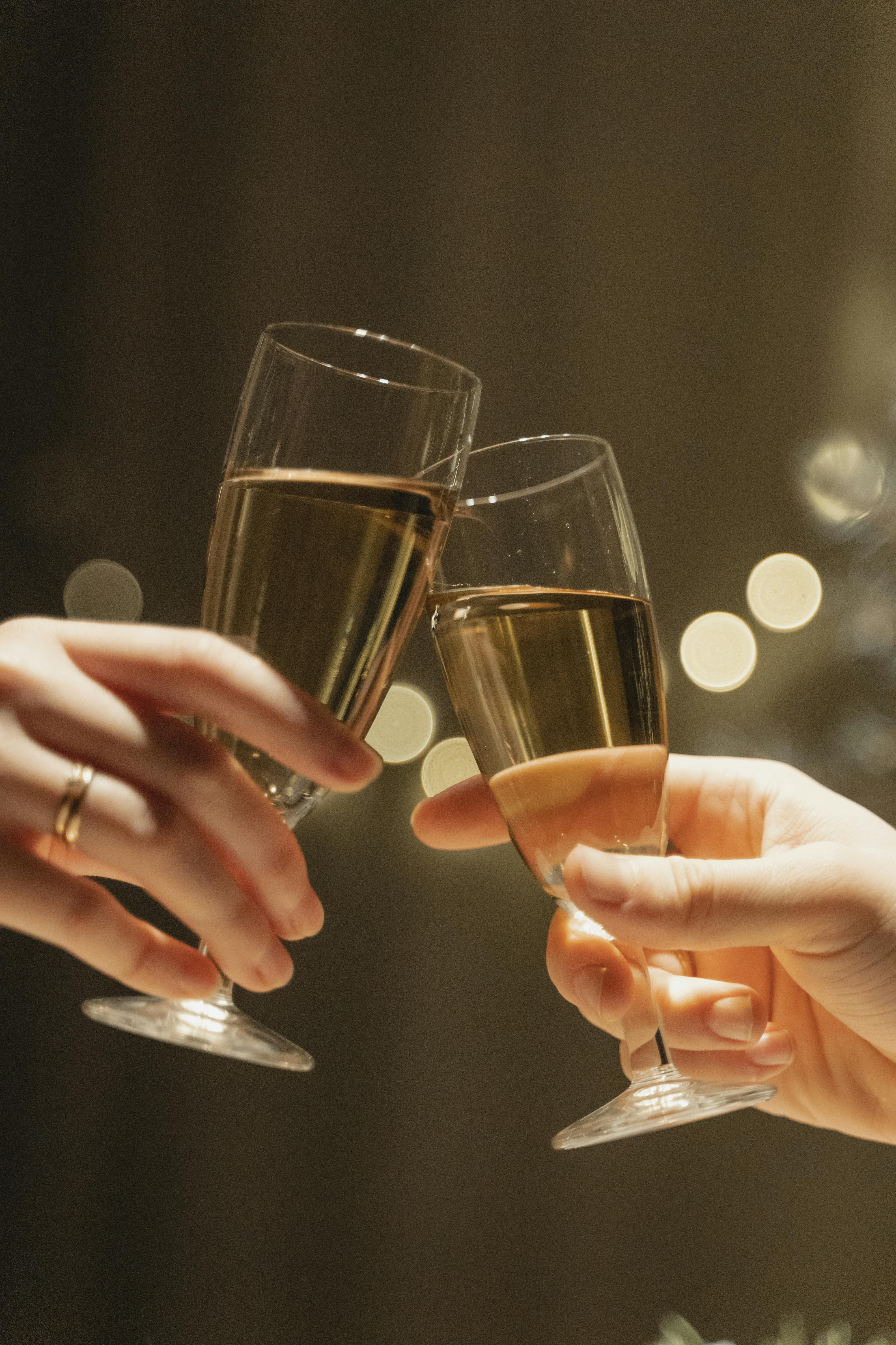 close up shot of hands having a toast using a glass of champagne