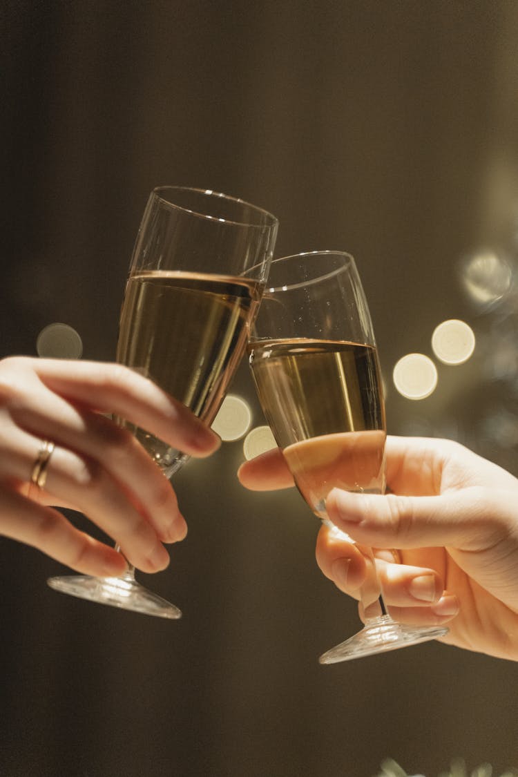 Close-up Shot Of Hands Having A Toast Using A Glass Of Champagne