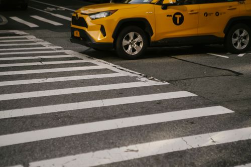 Free Stylish expensive yellow SUV taxi car stopped at zebra crossing in modern city district Stock Photo