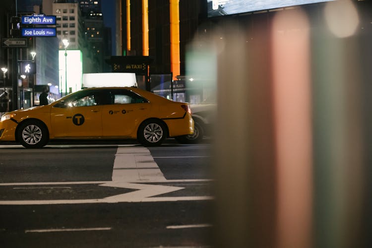 Contemporary Taxi Car Driving On City Street At Night