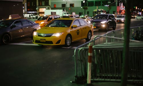 Taxi and vehicles driving on road in evening