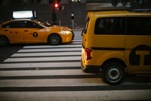 Various shiny yellow cabs driving on street in evening