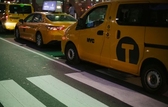 纽约市的街道上，夜间停着各种现代黄色出租车