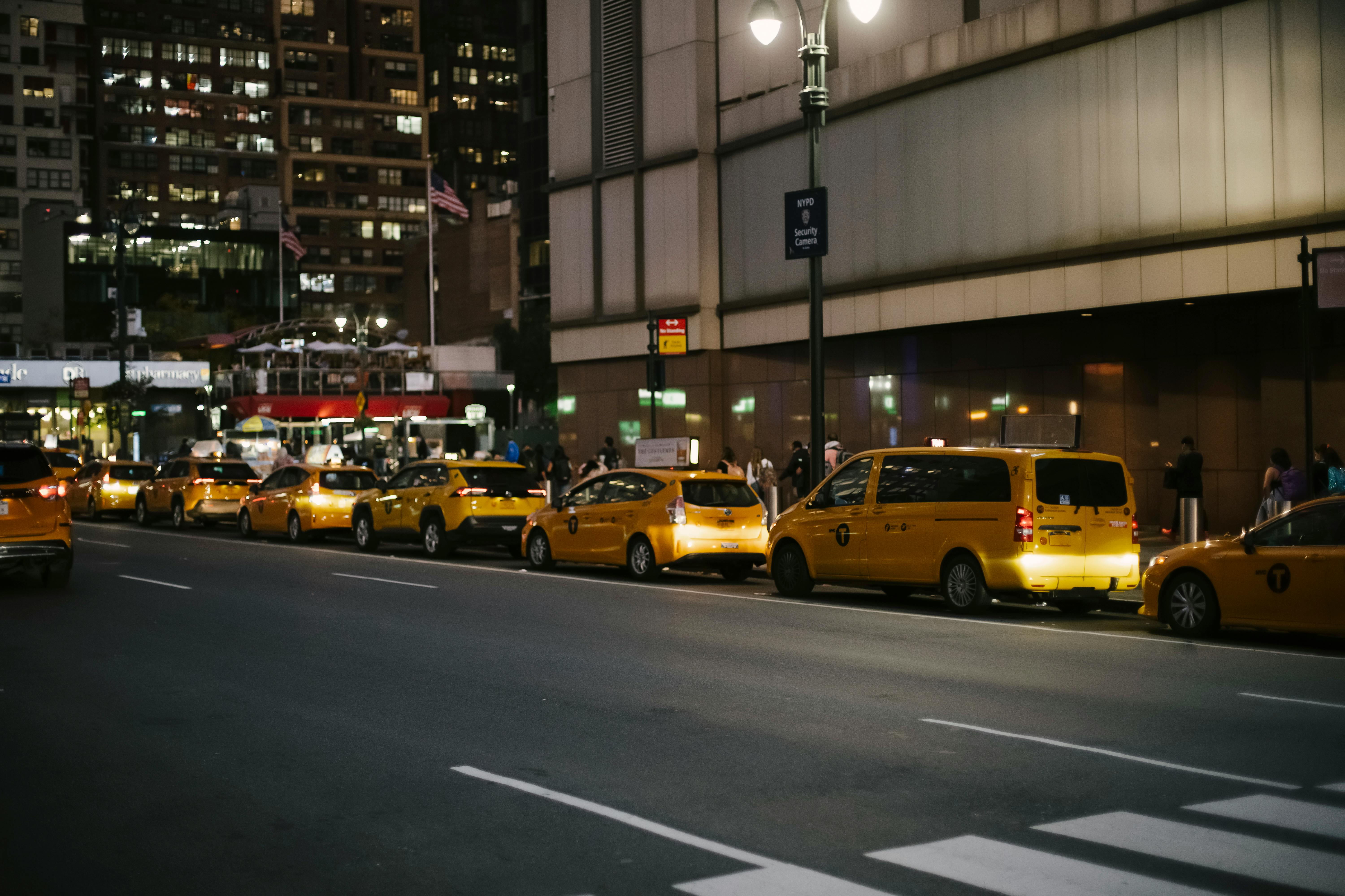 contemporary various yellow cabs parked on street at night