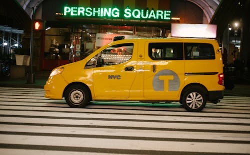 黃色小型貨車晚上可以停在城市街道上的咖啡館附近