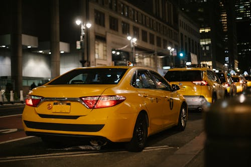 Free Yellow cabs driving along road at night Stock Photo