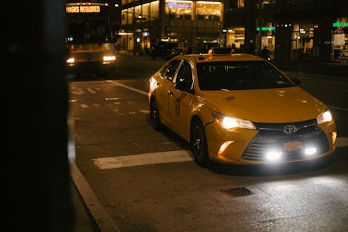 Taxi Samochód I Autobus Jadący Drogą W Nowoczesnym Mieście W Nocy