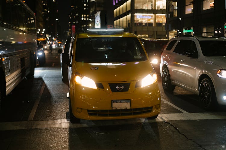 Shiny Cab And Automobiles Driving On Night City Street