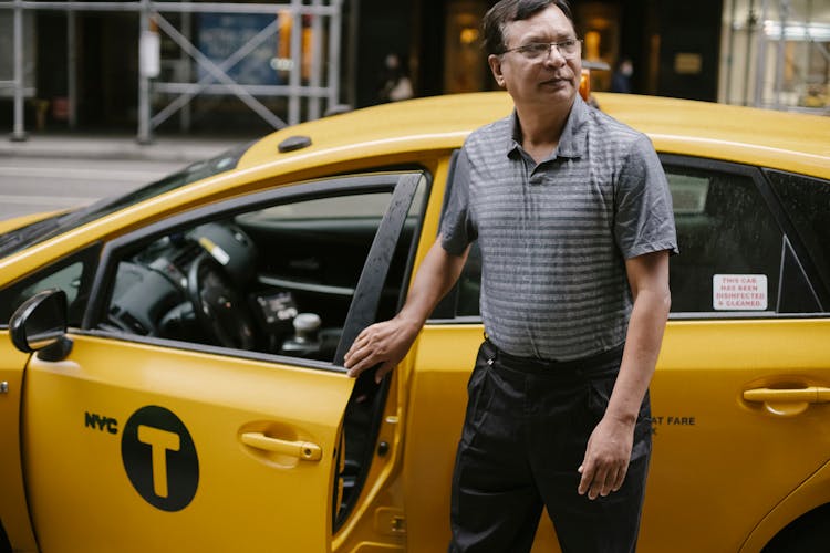 Focused Taxi Driver At Cab On Street