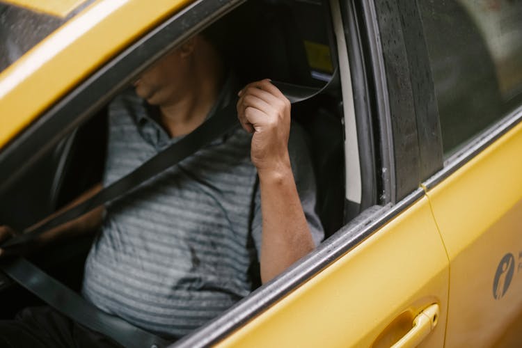 Unrecognizable Male Driver Sitting In Cab And Fastening Seat Belt