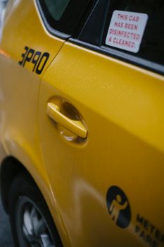 一辆现代、干净、闪亮的黄色汽车停在柏油路上，车身贴有贴纸和铭文