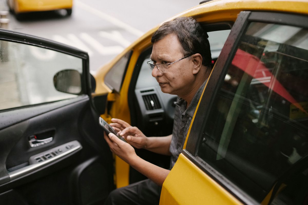 A driver checking passenger details on their phone before a ride