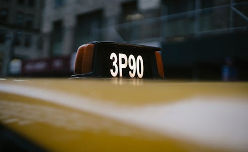Modern yellow taxi roof with number sign on black background