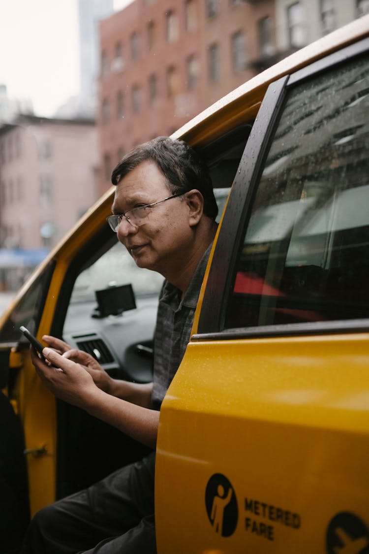 Calm Man With Smartphone Sitting In Car