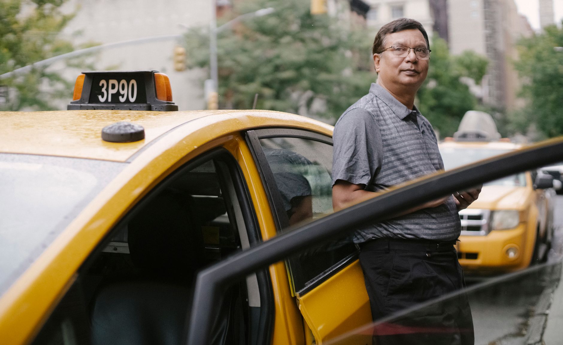 운전자보험과 개정 후 상품, 보장 차이만 깔끔 정리 4 Asian taxi driver standing beside a yellow cab in the city with an open door.