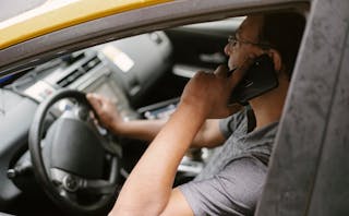 Focused driver speaking on smartphone in car