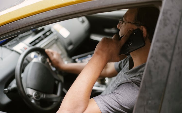 Focused Driver Speaking On Smartphone In Car