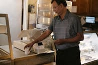 Ethnic man with cup of coffee at counter