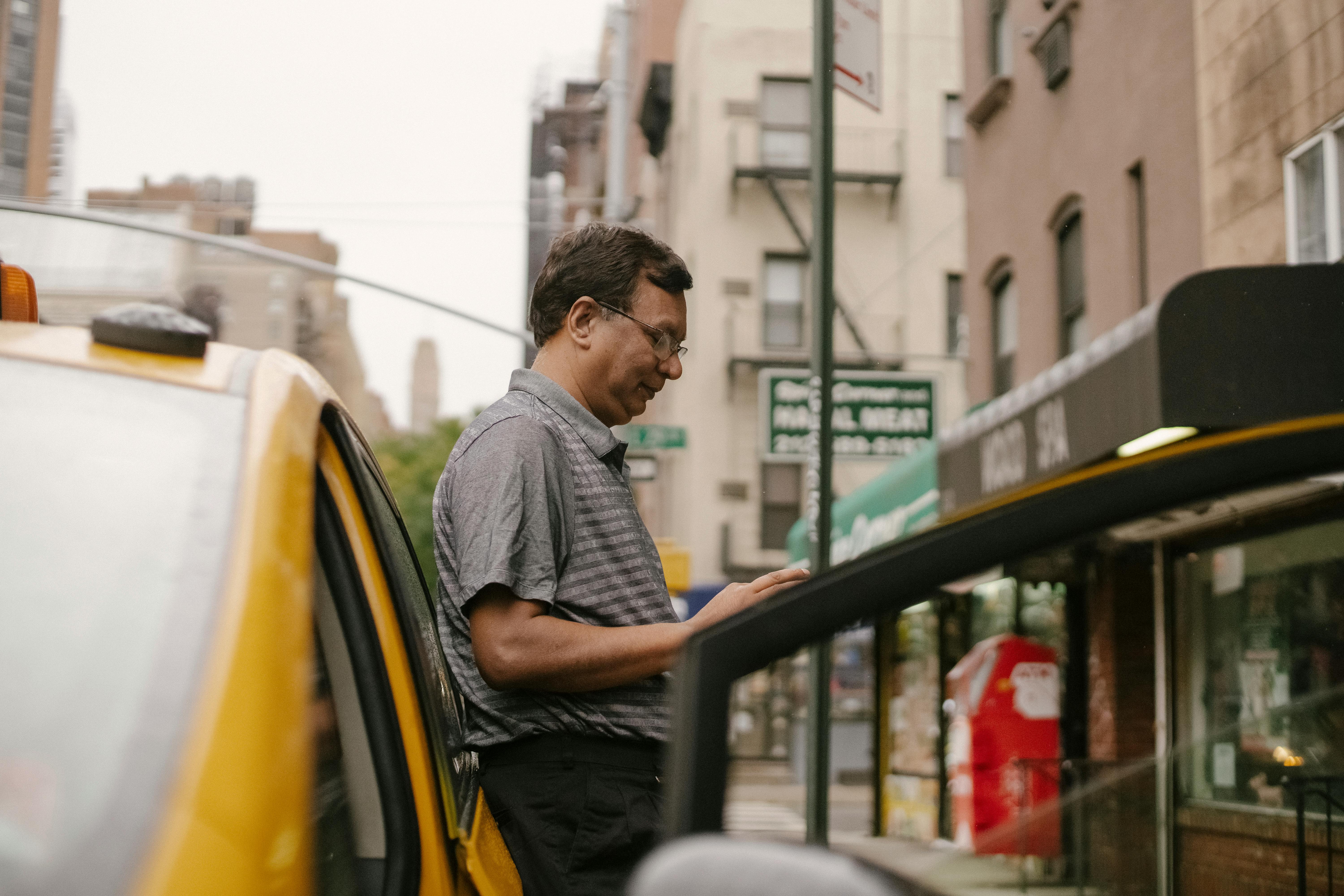 thoughtful ethnic man leaning on car