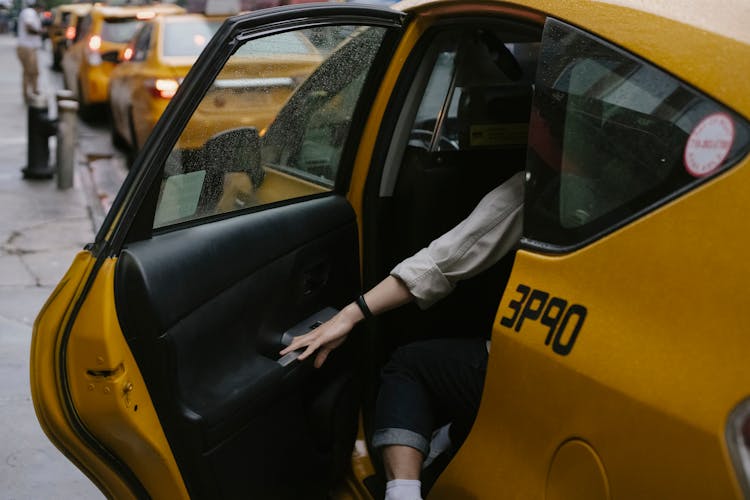 Crop Person Closing Door Of Yellow Taxi