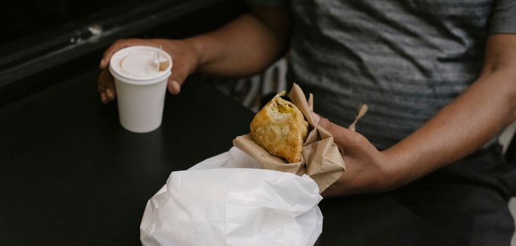 一名男子喝着热饮和油炸糕点，享受休闲的咖啡时光