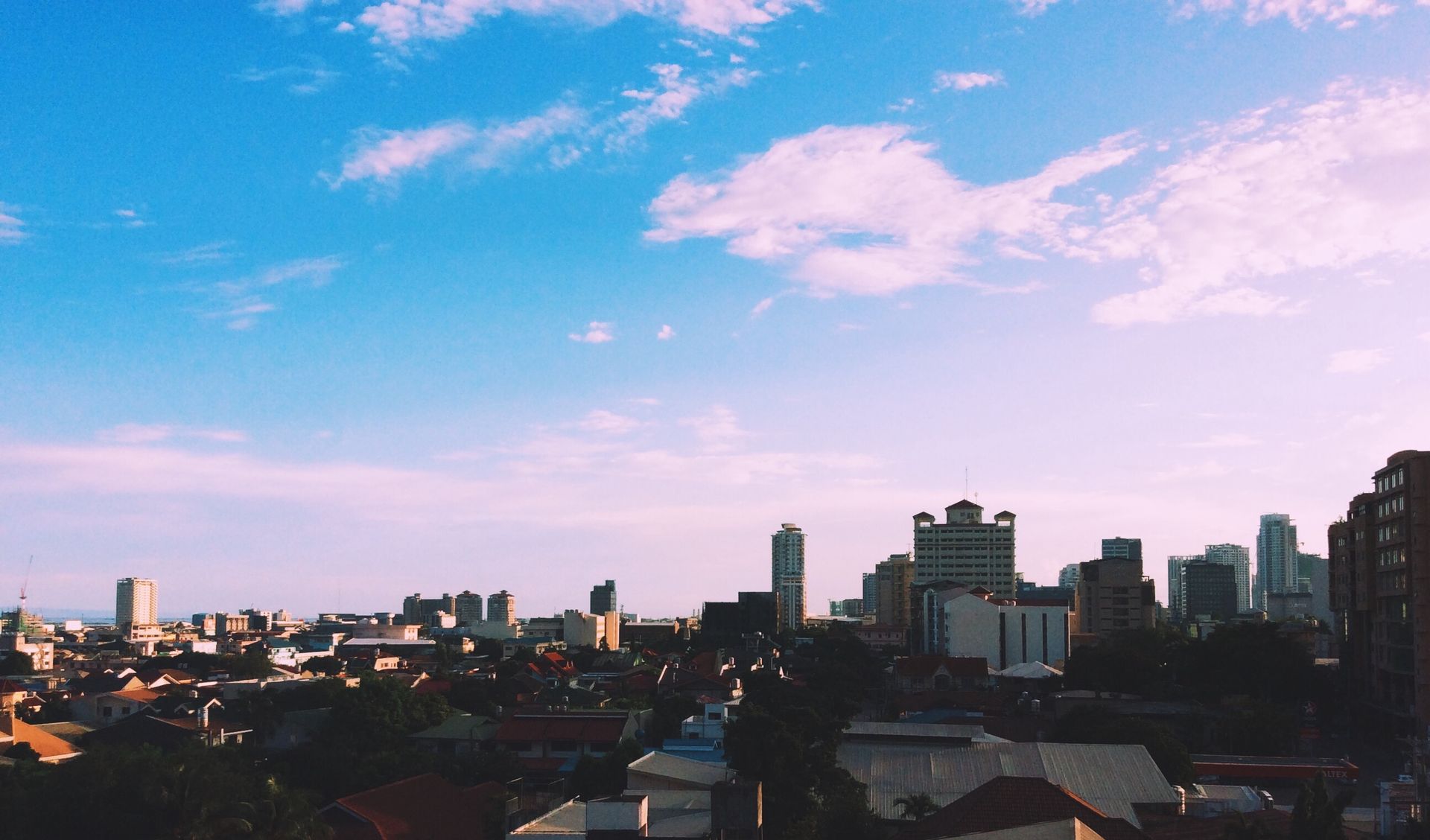 City skyline with skyscrapers and blue sky, offering a panoramic urban view.